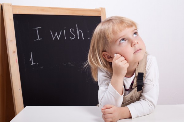little girl looking up with chalk thinking about wish list