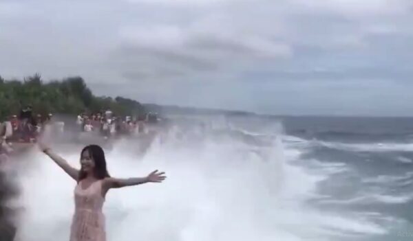Girl Stands On A Cliff And Poses With Her Arms Wide Open. A Huge Wave Comes And Takes Her Away - RVCJ Media